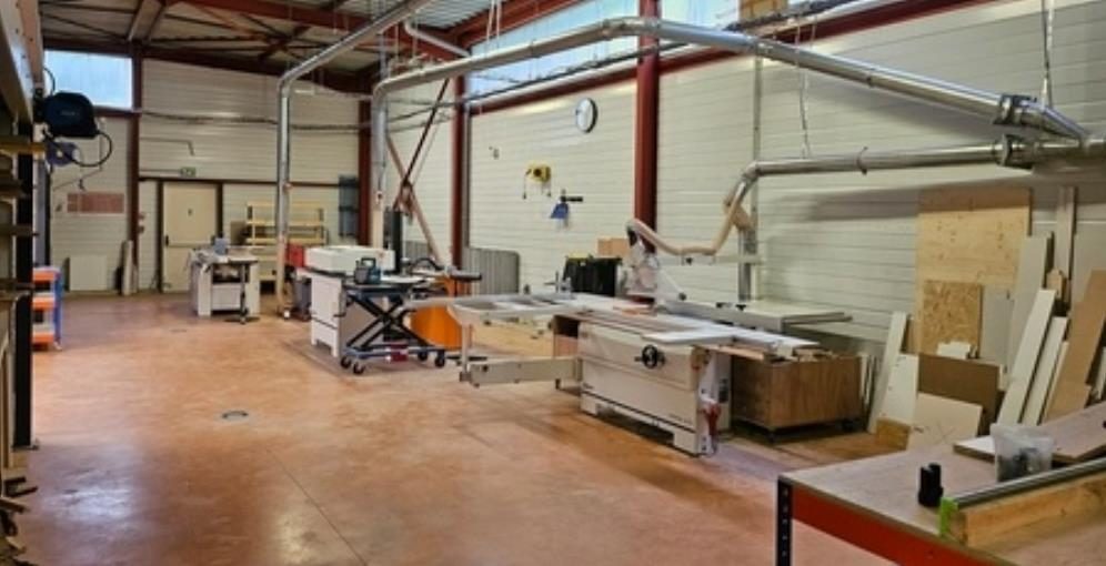 Atelier de menuiserie avec scie à panneaux, machines à bois et réseau d'aspiration